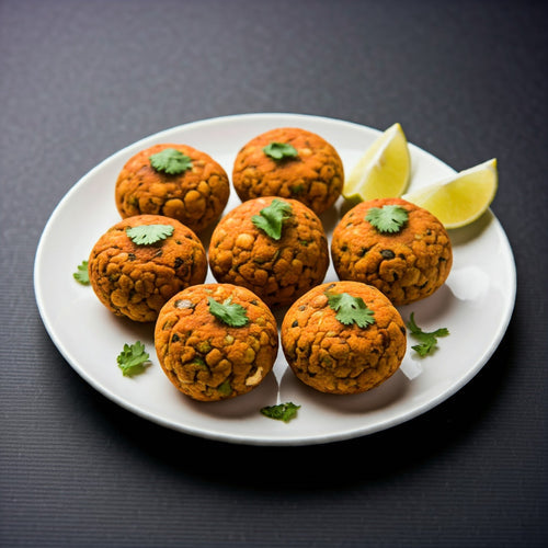 Plate of Spicy Makhana Tikki garnished with coriander leaves and lemon wedges on a white plate